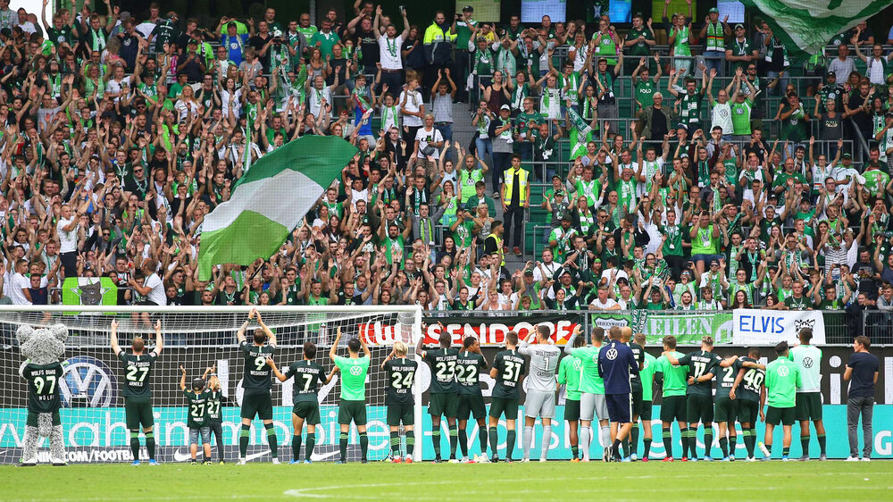 Die Spieler des VfL Wolfsburg stehen vor der Fankurve und bedanken sich bei den Fans.