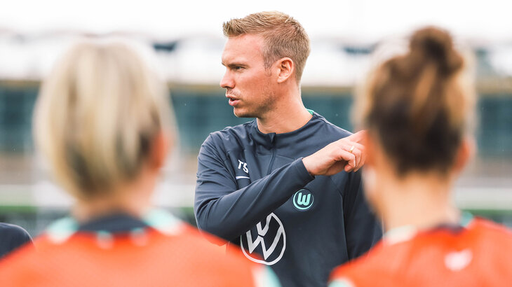 VfL-Wolfsburg-Frauentrainer Tommy Stroot redet mit seinen Spielerinnen.