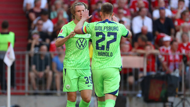 Die beiden VfL-Wolfsburg-Spieler Patrick Wimmer und Maximilian Arnold klatschen sich vorm Spiel ab.