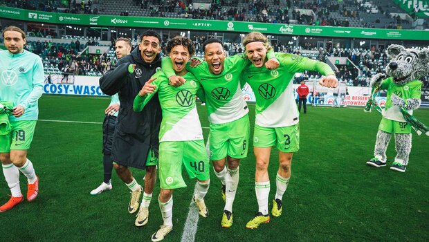 Die Spieler des VfL Wolfsburg umarmen sich und bejubeln ihren Treffer. 