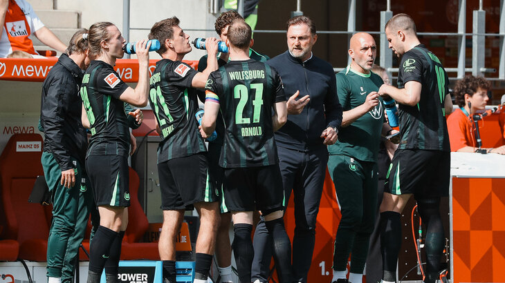 Die VfL Wolfsburg-Spieler stehen um Trainer Ralph Hasenhüttl, der Anweisungen gibt.