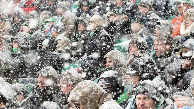 Fans bei Schnee im Stadion.