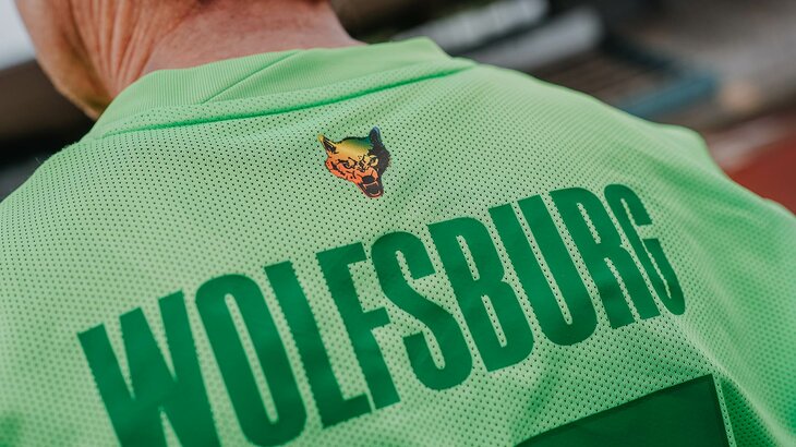 Ein VfL-Wolfsburg-Trikot von hinten mit einem Wolf in Regenbogen-Farben im Nacken.