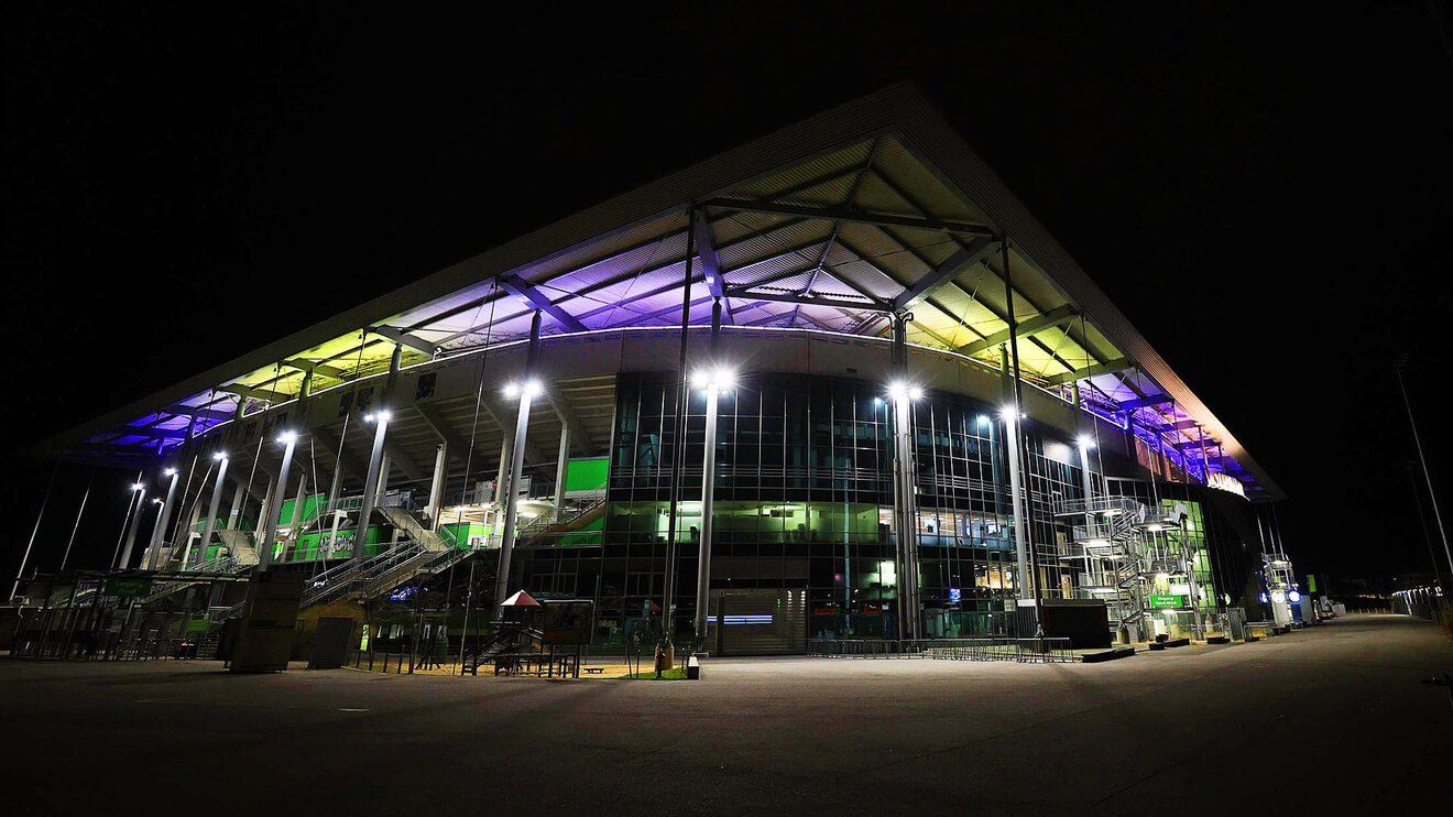 Die Volkswagen Arena bei Nacht beleuchtet in bunten Farben.