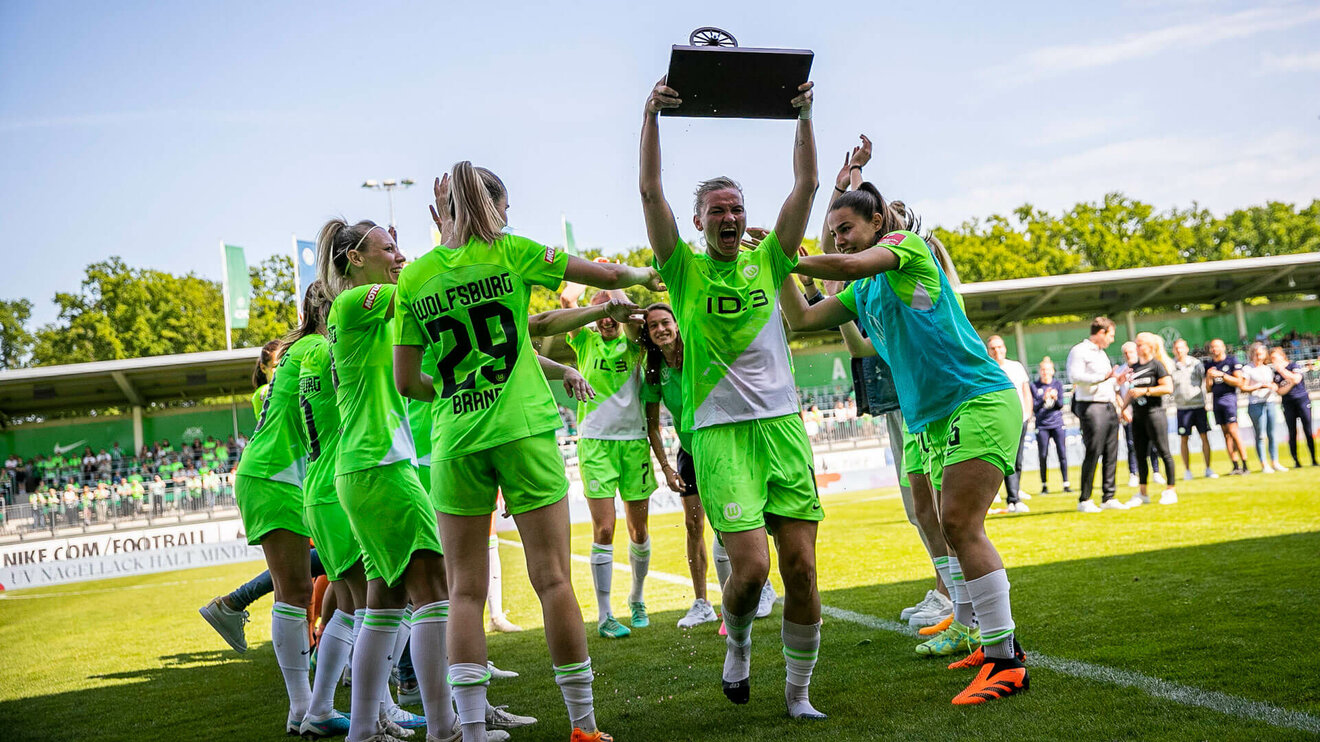 VfL-Wolfsburg-Spielerin Alexandra Popp hebt die Torjägerinnen-Kanone in die Luft und wird dabei vom Team bejubelt.