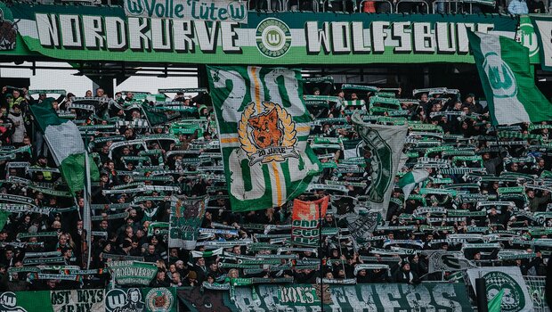 Choreografie der VfL-Wolfsburg-Fans mit erhobenen Schals und wehenden Fahnen.