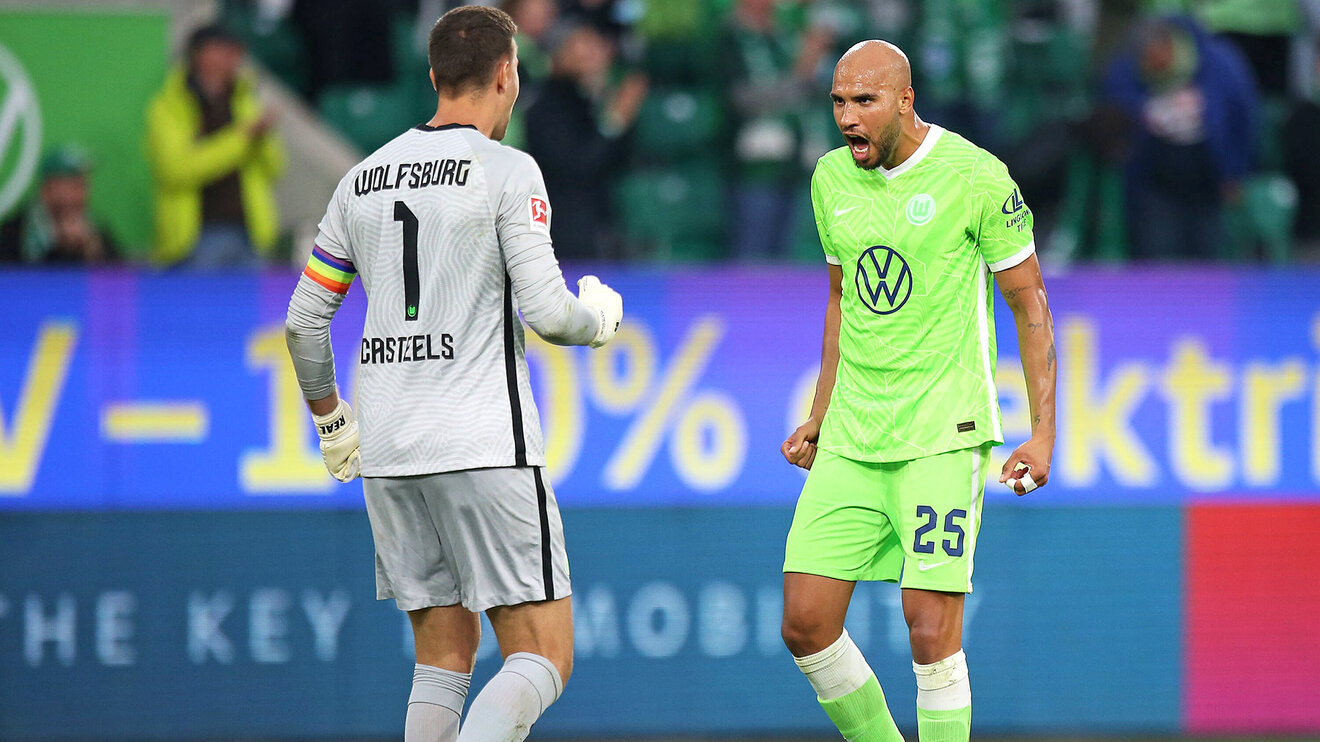 VfL-Wolfsburg-Spieler John Brooks und Koen Casteels freuen sich über eine gelungene Abwehraktion.