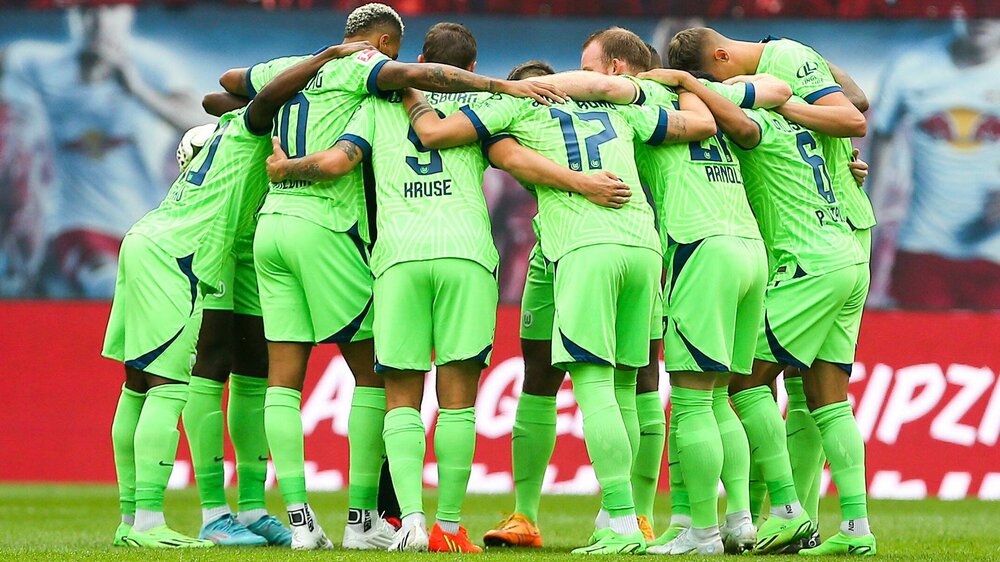 Die Spieler des VfL Wolfsburg bilden einen Kreis.