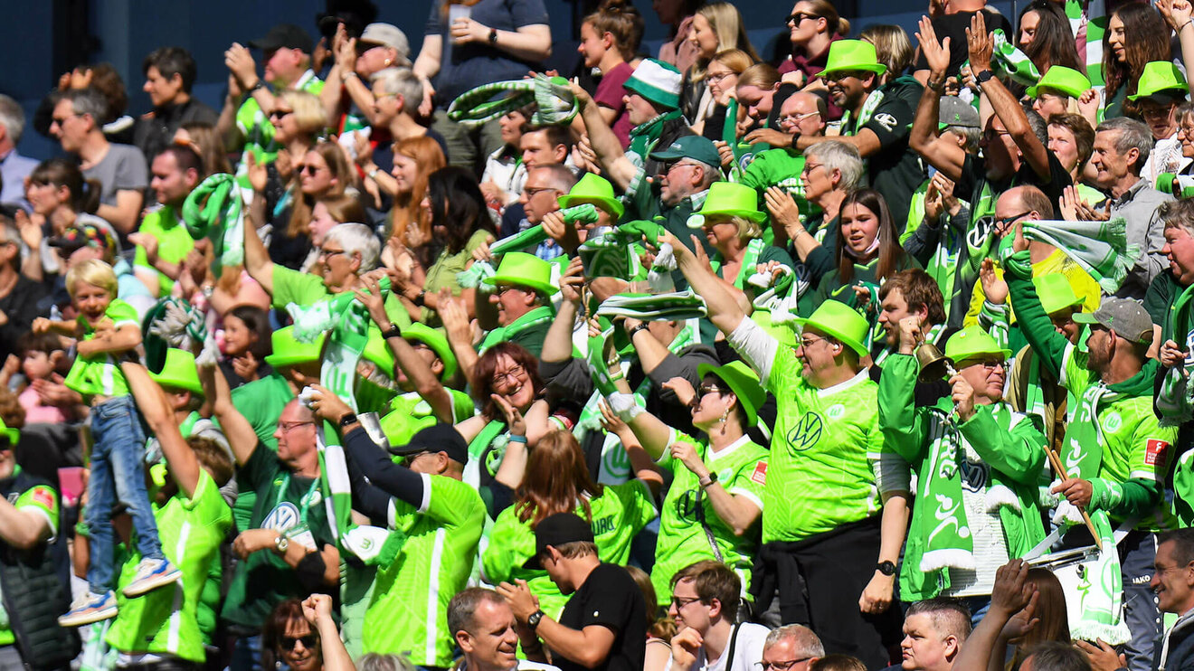 die Fans des VfL-Wolfsburg jubeln gemeinsam.