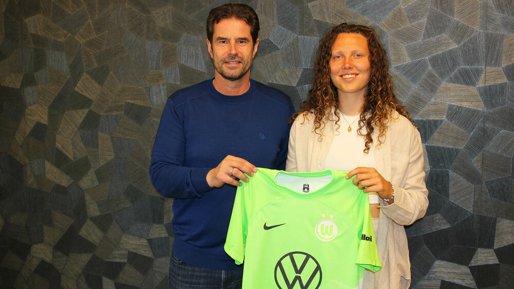 Fenna Kalma, Neuzugang des VfL Wolfsburg, hält mit Ralf Kellermann ein VfL Trikot hoch.