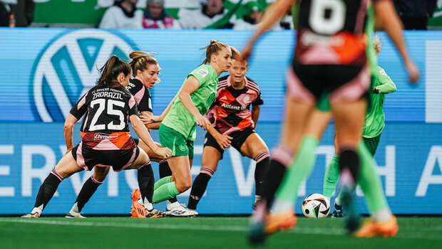 VfL-Wolfsburg-Spielerin Vivien Endemann hat den Ball am Fuß und ist umringt von Spielerinnen des FC Bayern.