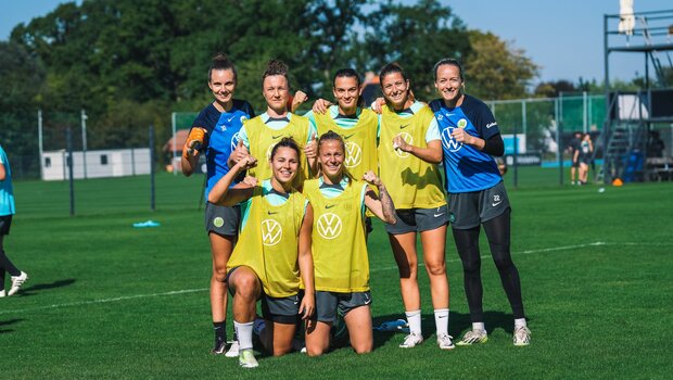 Ein Team aus mehreren VfL Wolfsburg-Spielerinnen stellt sich für ein Gruppenfoto auf.