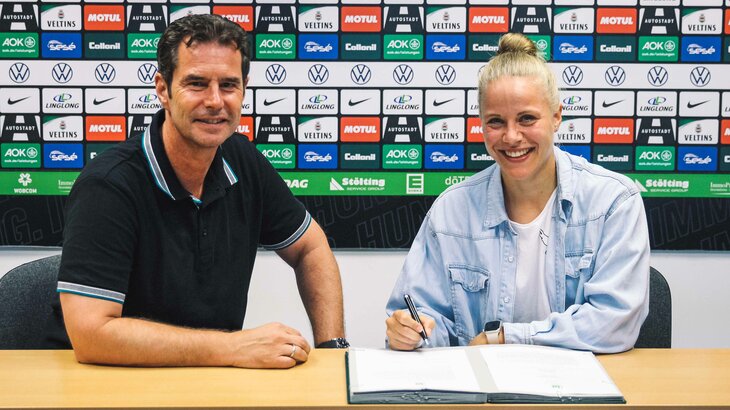 Pia-Sophie Wolter verlängert ihren Vertrag beim VfL Wolfsburg und setzt neben sportlichem Leiter Ralf Kellermann ihre Unterschrift unter den Vertrag.