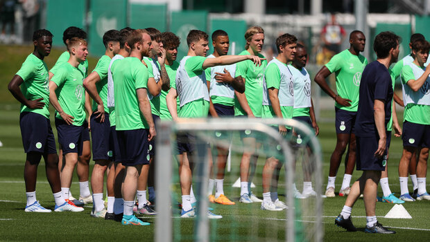 Die Spieler vom VfL Wolfsburg stehen zusammen auf dem Trainingsplatz.
