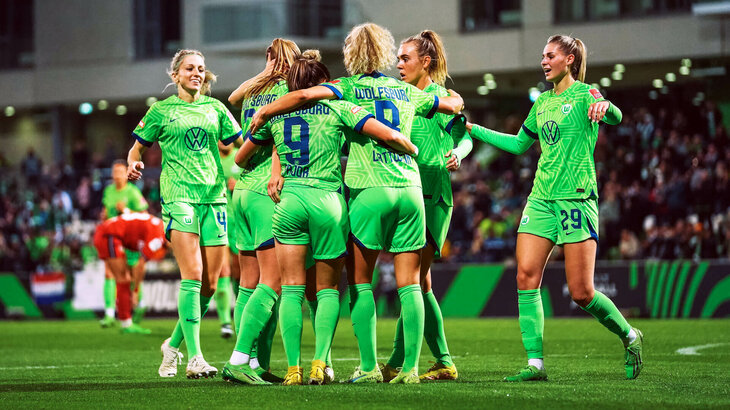 Die Spielerinnen des VfL-Wolfsburg stehen jubelnd beisammen.