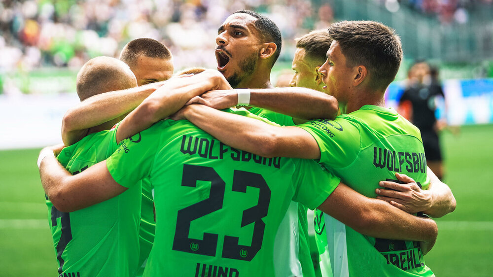 Die Spieler des VfL Wolfsburg jubeln gemeinsam.
