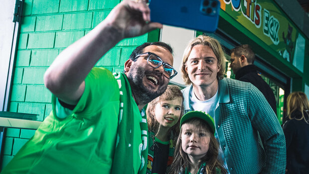 VfL Wolfsburg Spieler Sebastiaan Bornauw macht beim Familienspieltag in der Volkswagen Arena ein Selfie mit Fans.