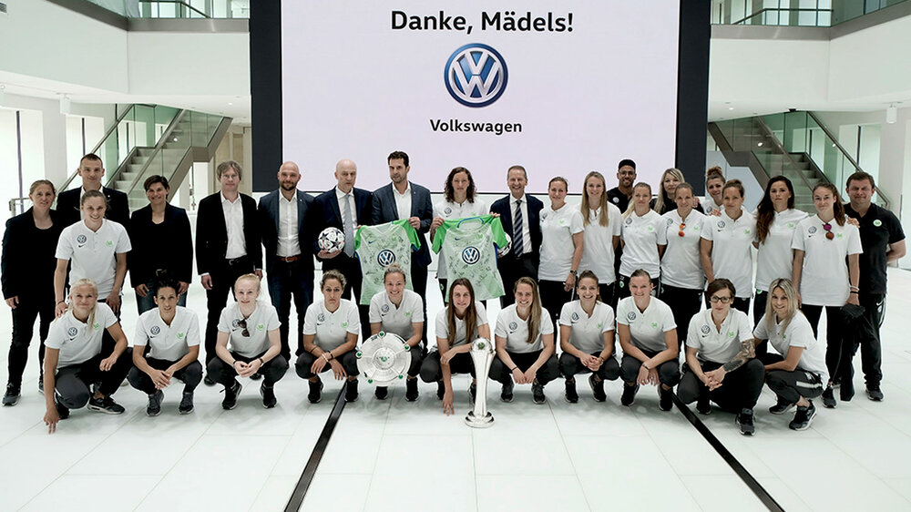 Ein Gruppenbild der Frauen mit VW. 