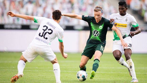 VfL Wolfsburg-Spieler Gerhardt im Kampf um den Ball mit zwei Gegenspielern aus Mönchengladbach.