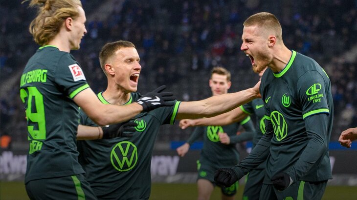 Spieler des VfL Wolfsburg jubeln voller Emotionen gemeinsam.