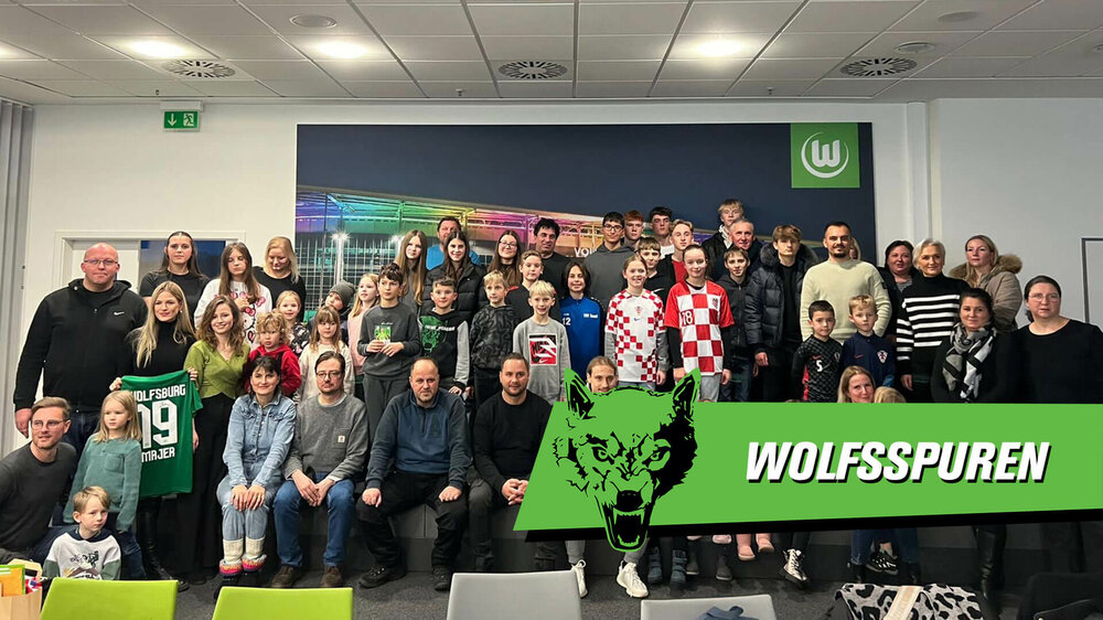 Eine VfL-Wolfsburg-Grafik mit dem Gruppenbild der Kinder bei der Kinder-Pressekonferenz mit Lovro Majer.