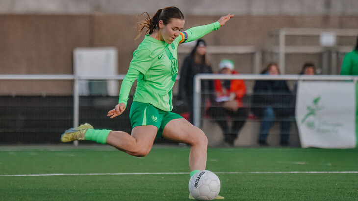 Eine U20 Spielerin des VfL Wolfsburg holt auf dem Spielfeld aus um gegen den Ball zu treten.