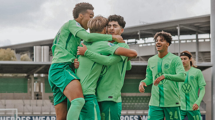 Die Spieler der U19-Mannschaft des VfL Wolfsburg nehmen sich in die Arme und Jubeln.
