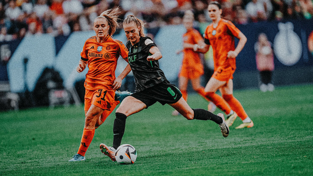 VfL-Wolfsburg-Spielerin Janina Minge setzt sich mit dem Ball am Fuß gegen eine Gegenspielerin aus München durch.