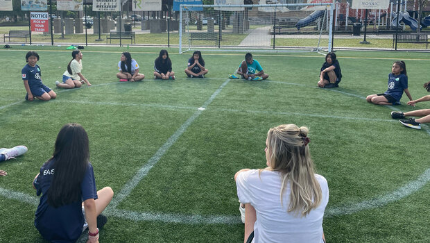 Mädchen sitzen in einem Kreis beim Strong Her Event des VfL Wolfsburg.