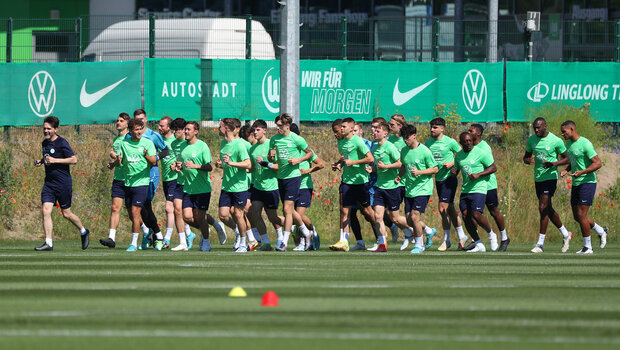 Die Spieler vom VfL Wolfsburg laufen zusammen auf dem Trainingsplatz.