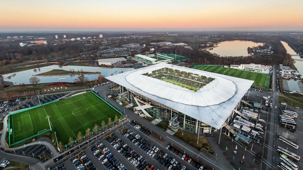 Die Volkswagen Arena, die Spielstätte des VfL Wolfsburg, mit den angrenzenden Parkplätzen.