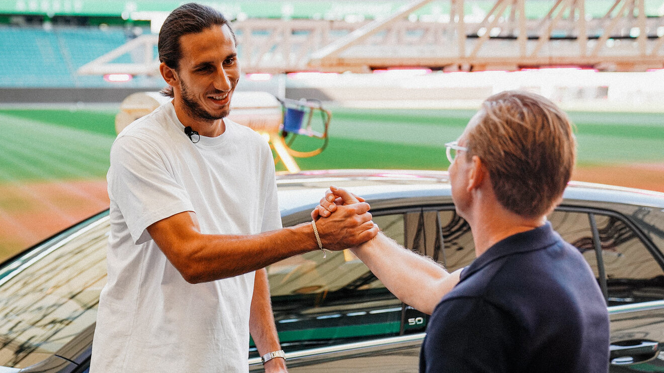 Der VfL-Wolfsburg-Spieler Kamil Grabara und Roy Präger schütteln sich die Hände.