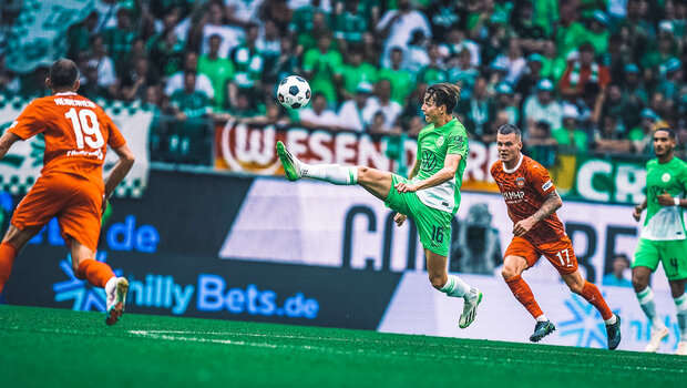 Ein ehemaliger Spieler des VfL Wolfsburg spielt den Ball in der Luft.