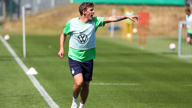 Der VfL Wolfsburg-Spieler Max Kruse zeigt beim laufen mit dem Finger in deine Richtung.