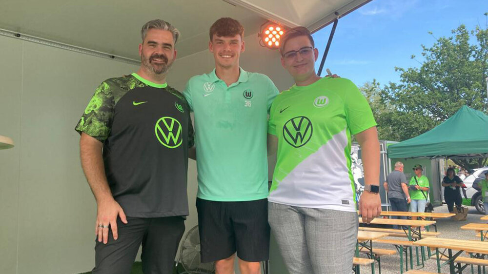 Die neuen Moderatoren Julia Wittbrodt und Simon Groth posieren zusammen mit VfL-Spieler Lukas Ambros auf der Bühne.