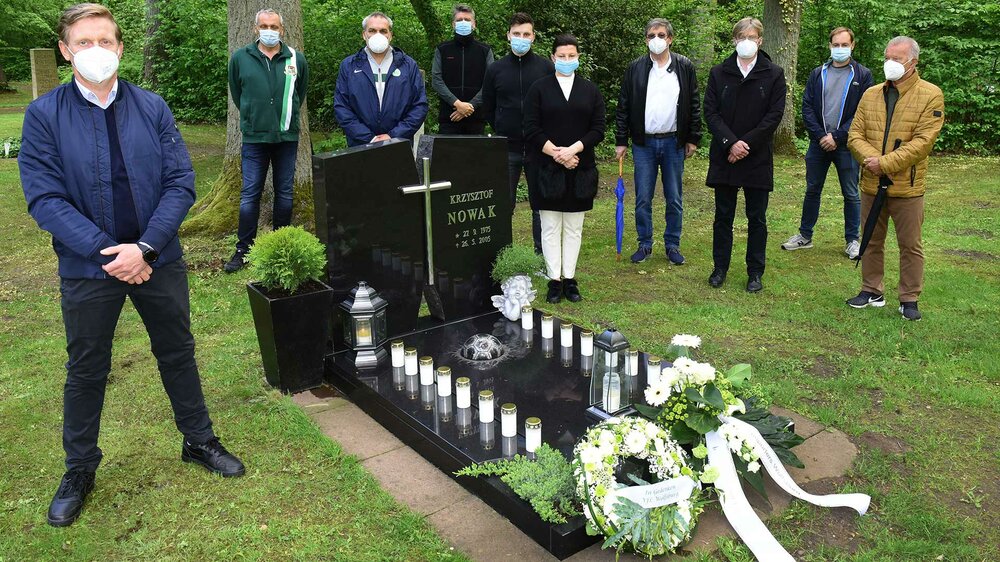 VfL Wolfsburg-Mitarbeiter stehen am Grab von Krzysztof Nowak.