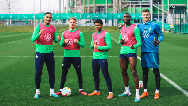 VfL Wolfsburg Spieler Cozza, Lacroix, Otavio, Guilavogui und Pervan posieren auf dem Trainingsplatz und halten den Daumen in die Höhe.