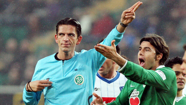 VfL-Wolfsburg-Spieler Andrea Bazargli im Austausch mit Schiedsrichter Deniz Aytekin.