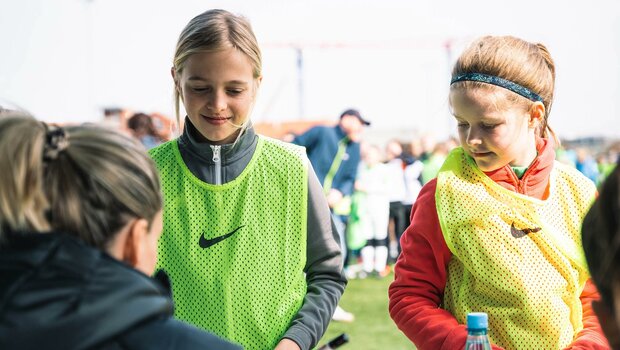Die Mädchen warten auf ihr Autogramm von den VfL-Wolfsburg-Spielerinnen.
