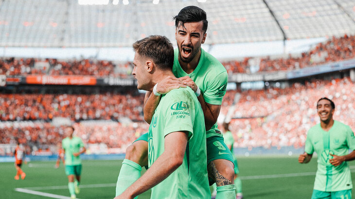 Der VfL-Wolfsburg-Spieler Mohammed Amoura jubelt zusammen mit Mattias Svanberg.
