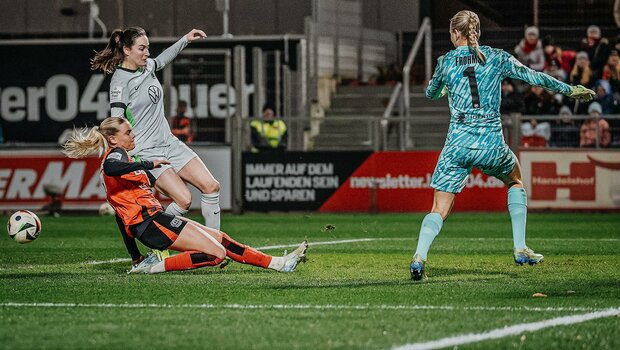 VfL-Wolfsburg-Spielerinnen Caitlin Dijkstra und Merle Frohms im Strafraum mit einer Gegenspielerin.