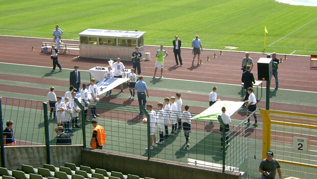 Die Einlaufinder für das U19-Pokalfinale 2007 stehen neben Bannern im Stadion am Elterweg.