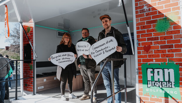 Mitglieder der Fanprojekts Wolfsburg mit Plakaten gegen Hass.