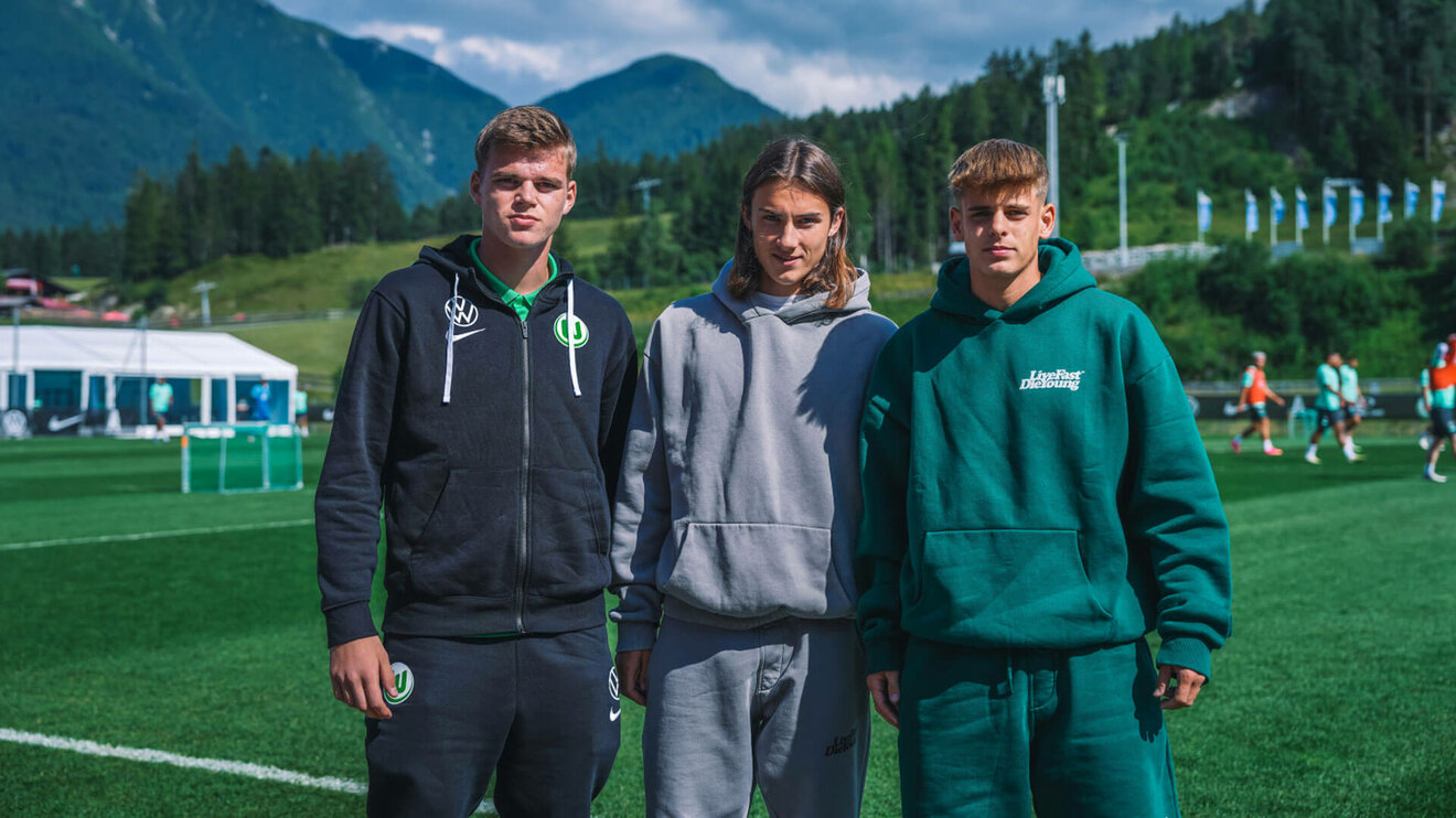 Drei VfL-Wolfsburg-Junioren stehen nebeneinander auf dem Trainingsplatz.
