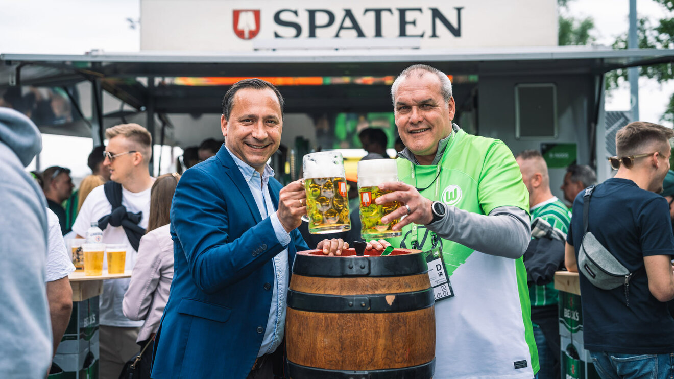 VfL-Wolfsburg-Fanbeauftragter Holger Ballwanz und Christian Neuhäuser mit einem Bier in der Hand.