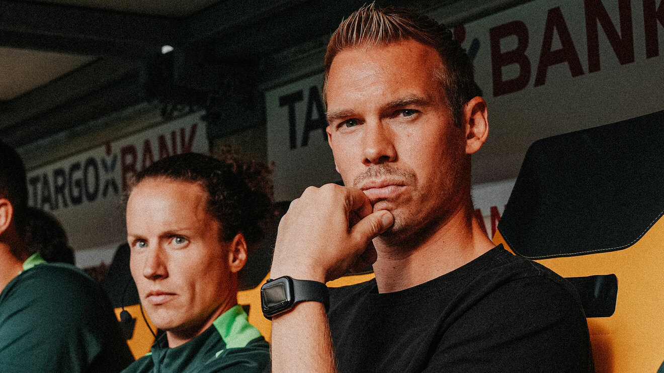 Tommy Stroot, Coach der Frauen des VfL Wolfsburg, sitzt auf der Bank.