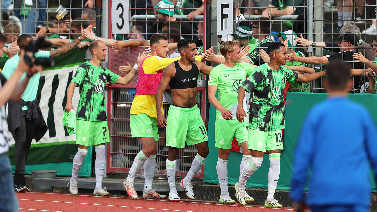 Spieler des VfL Wolfsburg klatschen die Fans beim Spiel gegen Makkabi Berlin ab.