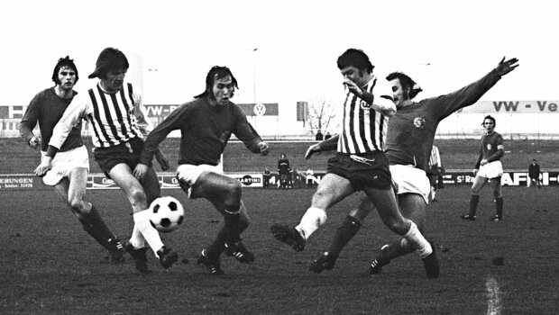 Ein historisches schwarz-weiß-Bild eines Zweikampfes bei einer Partie des VfL Wolfsburg gegen Kiel.