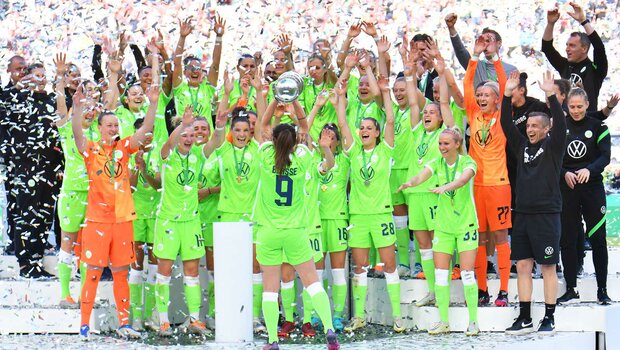 VfL-Wolfsburg-Spielerin Anna Blässe stemmt den DFB-Pokal vor der Mannschaft in die Höhe.