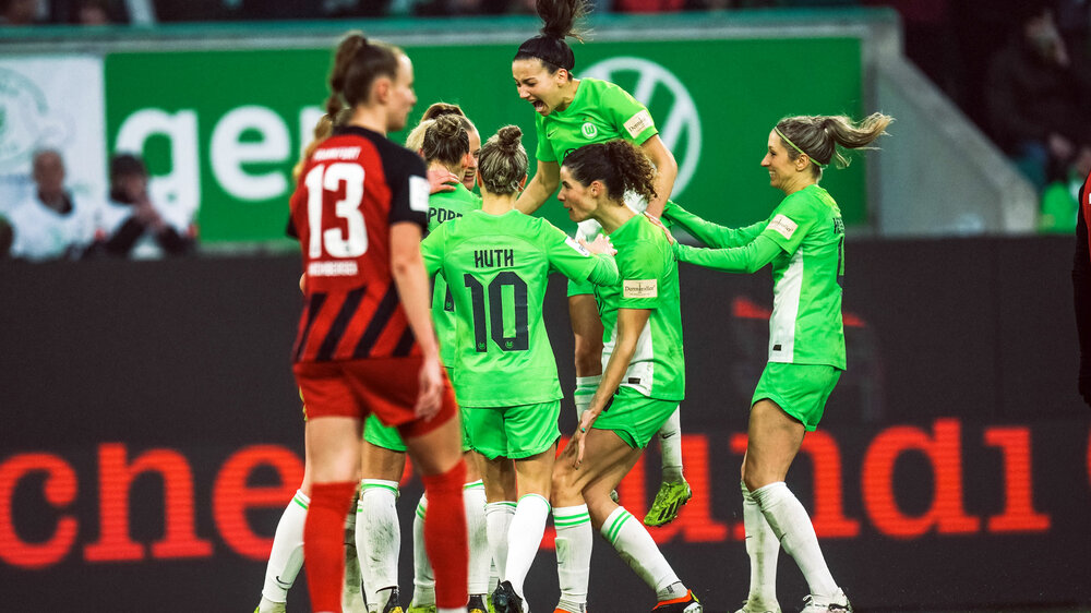 Joelle Wedemeyer vom VfL Wolfsburg springt auf die Jubeltraube der Frauen.